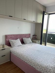 a bedroom with a large bed with a purple headboard at Apartament nou neo tower in Suceava