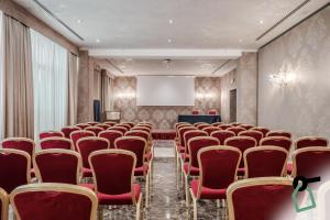 ヴェネツィアにあるHOTIDAY Room Collection - Venezia Santa Luciaの赤い椅子とスクリーン付きの会議室