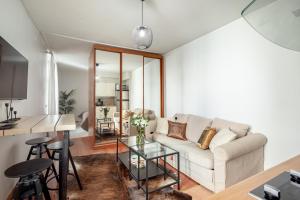 ein Wohnzimmer mit Sofa und Tisch in der Unterkunft New flat, best location Helsinki in Helsinki