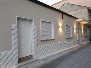 a white building with two windows and a door at B&B Villa Soleil in Vibo Valentia
