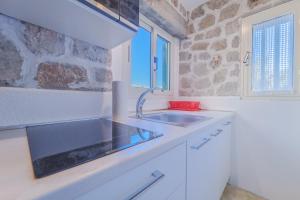 a kitchen with a sink and a stone wall at Casa William in Porto Azzurro +67 photos