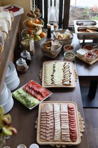 a table topped with plates of food on top at Garni Hotel Ema in Kragujevac