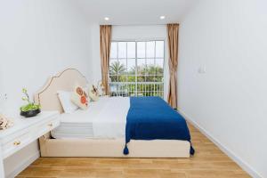 a white bedroom with a bed and a window at Nhà phố ven Biển view hồ cho 6-8 pax in Bình Tú +28 photos