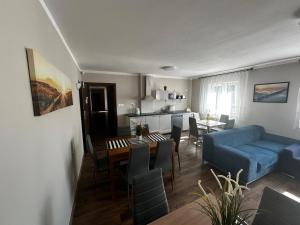 a living room with a blue couch and a table at Odyseusz Jastarnia in Jastarnia