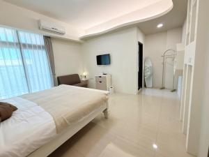 een ziekenhuiskamer met een bed en een tv bij 春日SpringDay花蓮包棟民宿 in Hualien