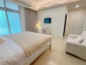 een slaapkamer met een bed, een bank en een tv bij 春日SpringDay花蓮包棟民宿 in Hualien +11 foto's