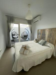 a bedroom with a white bed with a cross on it at Apartamento Alma in Las Negras