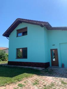 a white house with a blue facade at Casa Herban in Teliucu Inferior