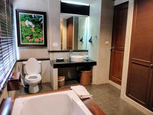a bathroom with a tub and a toilet and a sink at Chang Buri Resort & Spa in Ko Chang