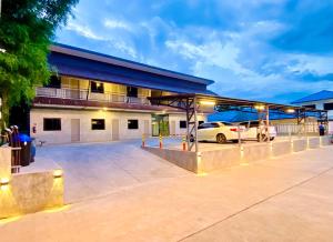 a parking lot in front of a building at บ้านต้นไม้เพลส อุทัยธานี in Uthai Thani