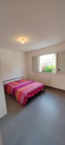 ein Schlafzimmer mit einem Bett in einem weißen Zimmer mit einem Fenster in der Unterkunft Maison de vacances in Saint-Clément-de-Rivière + 11 Fotos