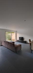 ein großes Wohnzimmer mit Sofa und TV in der Unterkunft Maison de vacances in Saint-Clément-de-Rivière