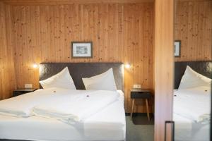 two beds in a room with wood paneling at Hotel Das Lisann in Pfelders +73 photos