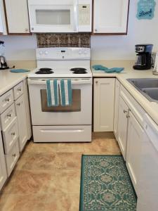 Una cocina con una estufa blanca y un fregadero. en Stunning Oceanfront Condo - The Seashore Hideaway, Wailua Bay View, Unit 208, Kapaa, en Kapaa 8 fotos más