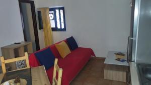 カターニアにあるCastellano Home - Ursinoの赤いソファとテーブルのあるリビングルーム