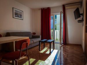 a living room with a couch and a table at Pansion Palme in Drvenik