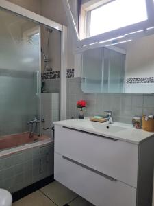 a white bathroom with a sink and a shower at La Gleyzinière 2 in Allevard
