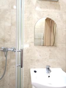 a bathroom with a sink and a shower with a mirror at Miramar in Łeba