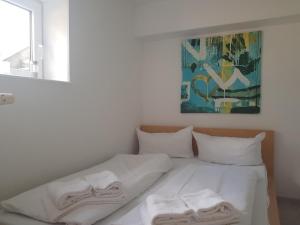 ein Bett mit weißen Laken und Handtüchern darauf in der Unterkunft Unterdeck in Wittdün