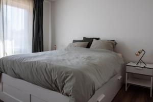 a white bed in a white bedroom with a window at ViaAmbioriX in Tongeren