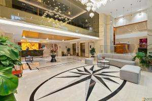 a living room with a large lobby with plants at 22Land Hotel Saigon in Ho Chi Minh City
