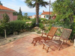 two chairs sitting on a patio with the ocean in the background at Appartement Balthasar - Turm Krk in Sveti Vid-Miholjice