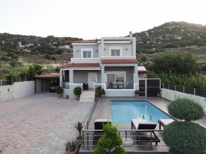 a house with a swimming pool in front of it at Luxury Villa Stironas private pool Central Crete in Stíronas