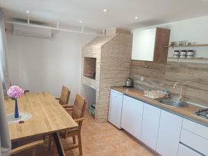 a kitchen with a wooden table and a dining room at Cozy room in Pula