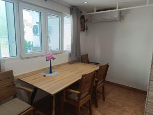 a dining room table with a vase of flowers on it at Cozy room in Pula
