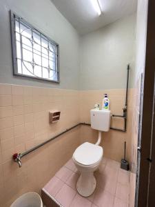 a bathroom with a white toilet and a window at 3 rooms Town Homestay 1 mins to Town in Teluk Intan