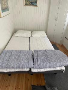 two twin beds in a room with wooden floors at Pikkumökki Sveastugan in Rövik