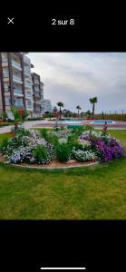 a garden of flowers in a park next to a pool at Residence amwej sousse in Sousse