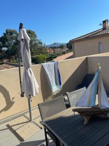 an umbrella and a table and chairs on a balcony at Saint-Cyprien Appartement de standing in Saint-Cyprien