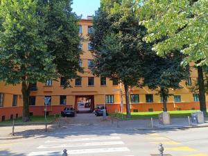 ein orangefarbenes Gebäude mit Bäumen davor in der Unterkunft Quiet Central in Ljubljana