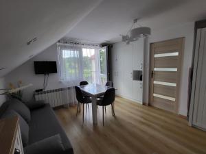 a living room with a table and chairs and a couch at Domek pod Hyrką Bieszczady-Lesko in Lesko