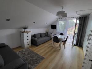 a living room with a couch and a table at Domek pod Hyrką Bieszczady-Lesko in Lesko +17 photos