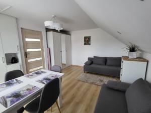 a living room with a table and a couch at Domek pod Hyrką Bieszczady-Lesko in Lesko