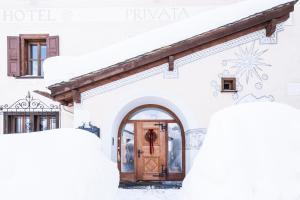 锡尔斯玛丽亚普利瓦塔酒店的雪中有一扇门的房子