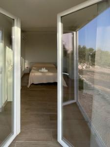 ペスキチにあるTenute le Difenseのガラスの引き戸越しに見た寝室の眺め