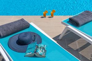 a table with a straw hat and a wallet and a pool at Elafonisos Aqua Villa I in Elafonisos