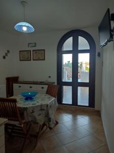 a dining room with a table and a window at Appartamenti Za Barbara in Lampedusa