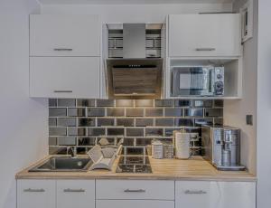 a kitchen with white cabinets and a counter top at Apartamenty Kowary in Kowary