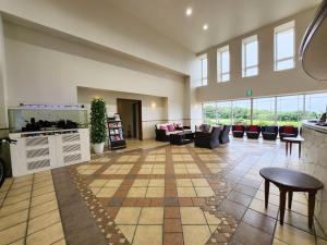 a large lobby with couches and tables and windows at Wellness Villa Brisa in Miyako Island