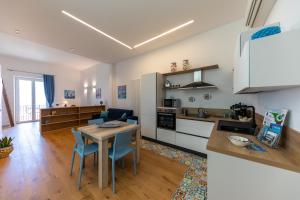 a kitchen and living room with a table and chairs at Amunì - Exclusive Suite in Centro a Cefalù Vista Mare by CEFALU BIZ in Cefalù