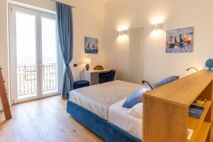 チェファルにあるAmunì - Exclusive Suite in Centro a Cefalù Vista Mareのベッドと大きな窓のある寝室