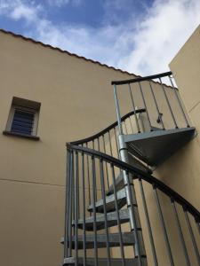 a spiral staircase next to a building with a window at Saint-Cyprien Appartement de standing in Saint-Cyprien +1 photo