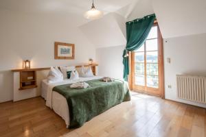 sypialnia z dużym łóżkiem i zielonym kocem w obiekcie Hotel Römerstein w mieście Loipersdorf bei Fürstenfeld +37 zdjęć