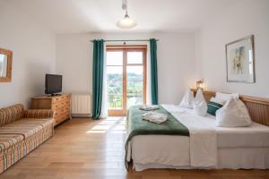 sypialnia z łóżkiem, kanapą i oknem w obiekcie Hotel Römerstein w mieście Loipersdorf bei Fürstenfeld