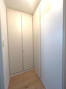 Habitación con armarios blancos y suelo de madera. en Wohnung mit wunderschönem Seeblick, en Gmunden