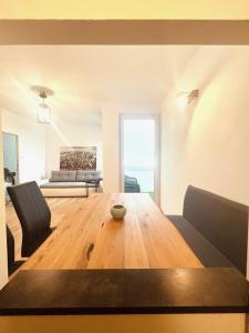 Una sala de estar con una mesa de madera y un sofá. en Wohnung mit wunderschönem Seeblick, en Gmunden